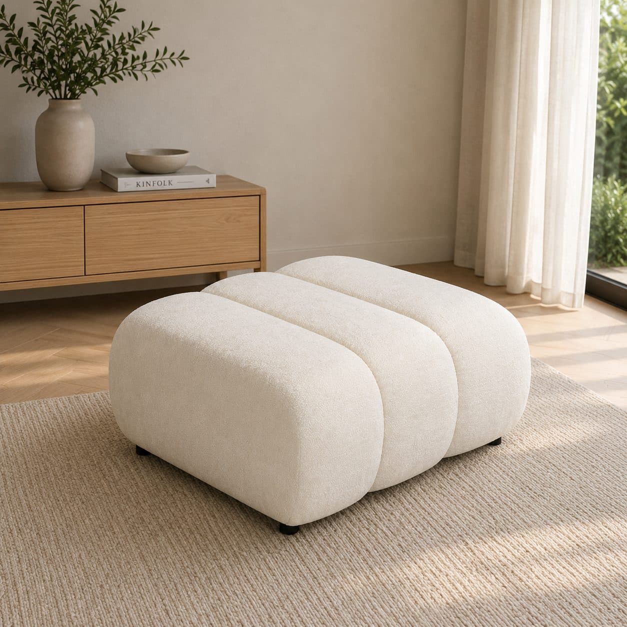 Pufa Mio do salonu – designerska pufa tapicerowana o zaokrąglonej, organicznej formie i szerokim wygodnym siedzisku.